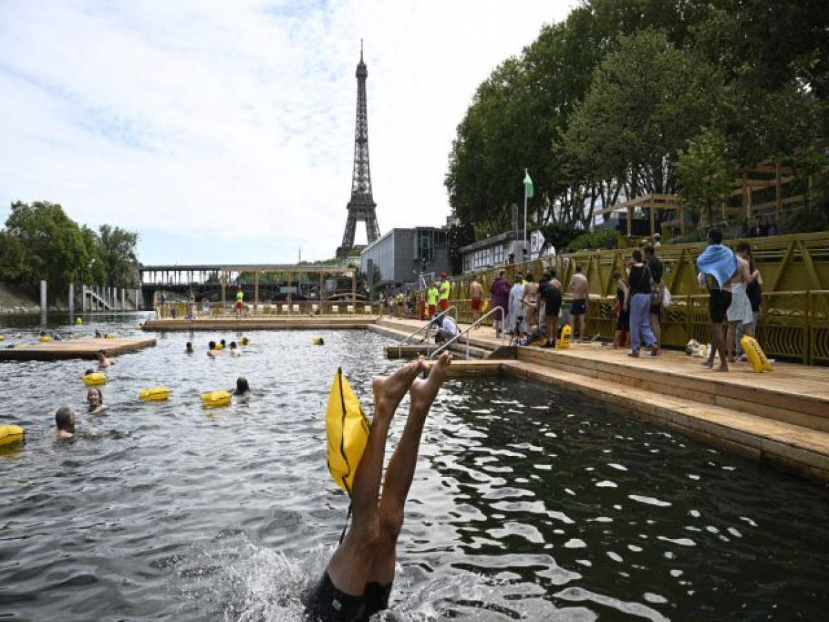 Banhistas mergulham no rio Sena, em Paris, reaberto para banho após 102 anos